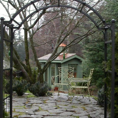 Mission style green garden shed was a custom construction by Bonney Lake Landscapes in Seattle, Washington.